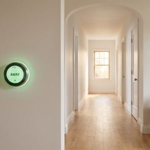 An elegant, quiet home interior showcasing a smart thermostat set to an energy-saving away mode.